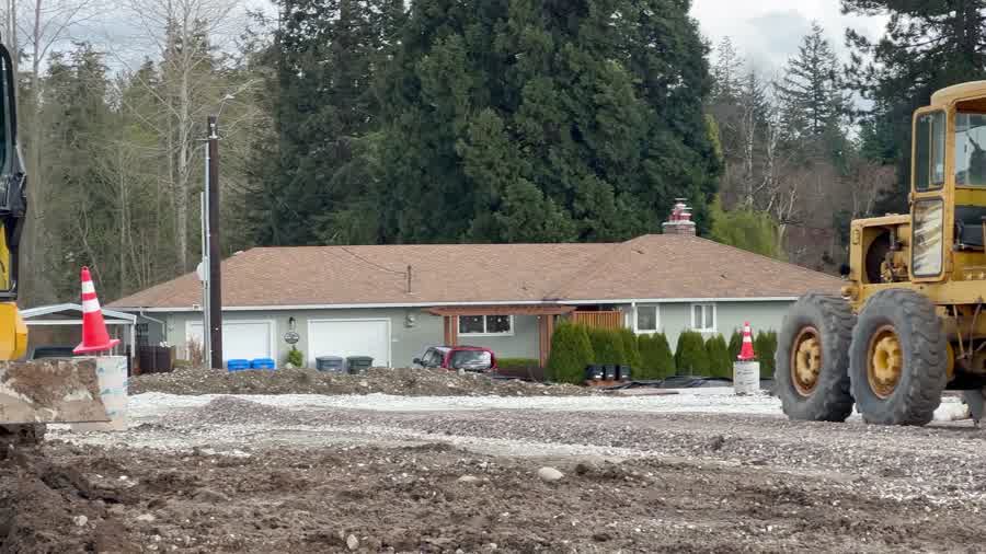 Excavator digging on a wooded residential development site near Boring, Oregon